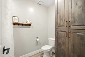 Bathroom featuring toilet and light wood finished floors