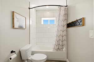Full bathroom with shower / bath combo and toilet
