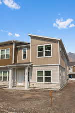 View of front of house with stone siding and a mountain view