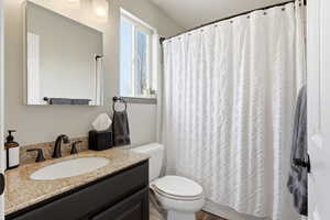 Bathroom featuring a shower with shower curtain and vanity