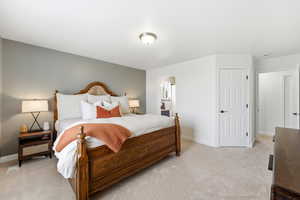 Bedroom featuring light colored carpet and connected bathroom