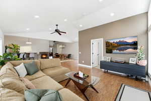 Living room featuring a ceiling fan, light wood-type flooring, vaulted ceiling, and recessed lighting