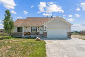 Ranch-style house with covered porch, an attached garage, stucco siding, concrete driveway, and brick siding