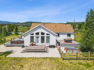Rear view of house with outdoor dining space, stucco siding, a patio area, and a deck with mountain view