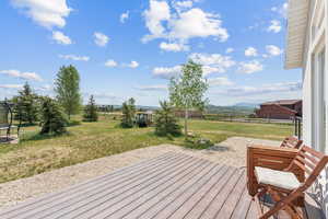 Wooden terrace with a trampoline and a fenced backyard