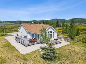 Back of house featuring a deck with mountain view, stucco siding, a view of rural / pastoral area, and french doors