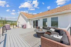 Wooden deck featuring grilling area and an outdoor living space with a fire pit