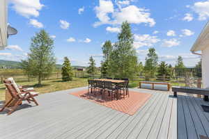 Wooden deck with outdoor dining area and a fenced backyard