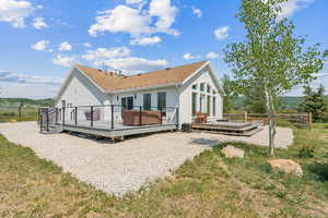 Rear view of house with a wooden deck and stucco siding