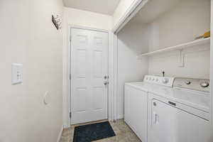 Laundry area featuring washer and dryer and baseboards