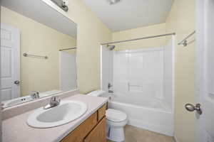Bathroom featuring vanity, shower / bath combination, and light tile patterned flooring