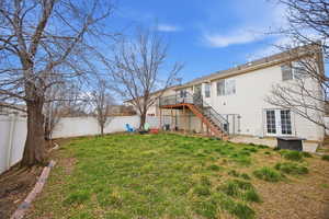 Rear view of property featuring a patio area, a fenced backyard, french doors, and a deck
