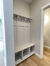 Mudroom featuring light wood finished floors and baseboards