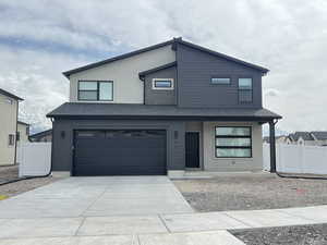 Contemporary home featuring covered porch, concrete driveway, a shingled roof, a garage, and stucco siding