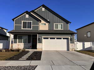 View of front facade featuring a gate, a garage, concrete driveway, a porch, and board and batten siding