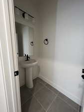 Bathroom with baseboards and dark tile patterned flooring