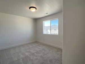 Unfurnished room featuring light carpet and baseboards