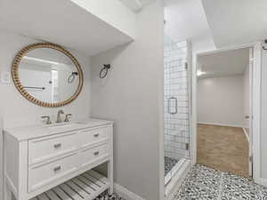 Bathroom featuring vanity, a shower stall, and light tile patterned flooring