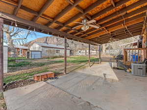 Fenced backyard with ceiling fan and a patio