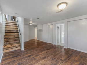 Living room with dark wood-style flooring and a textured ceiling