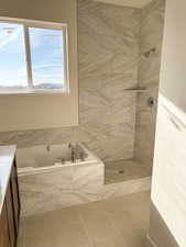 Full bathroom with vanity, a garden tub, and a tile shower