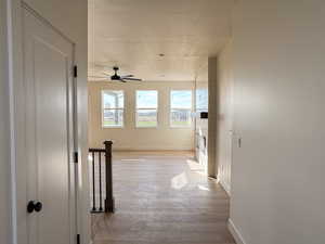 Hall with light wood-style floors and a textured ceiling