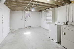 Unfinished below grade area featuring washer and clothes dryer