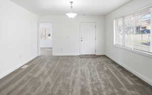 Unfurnished dining area featuring plenty of natural light and light colored carpet