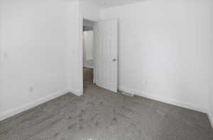 Unfurnished room featuring light colored carpet and baseboards