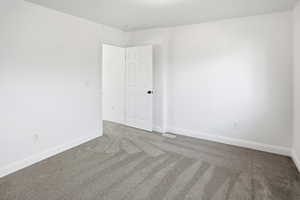 Carpeted empty room featuring baseboards