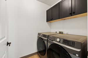 Laundry room with independent washer and dryer, cabinet space, and a textured ceiling