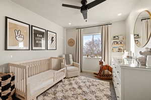 Bedroom with carpet floors, a nursery area, a ceiling fan, recessed lighting, and a textured ceiling