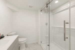 Full bath with vanity, a shower stall, light marble finish flooring, and recessed lighting