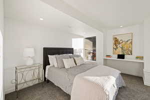 Bedroom with dark colored carpet and recessed lighting