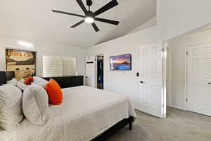 Bedroom featuring carpet flooring, vaulted ceiling, a spacious closet, and a ceiling fan