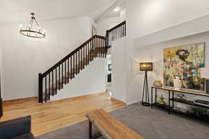 Stairs featuring wood-type flooring and hanging lights