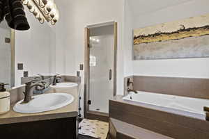 Bathroom with double vanity, a shower stall, and a bath