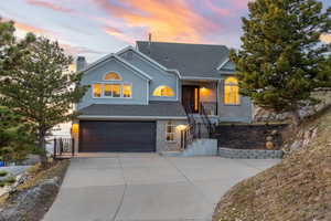 View of front of home featuring brick siding, an attached garage, concrete driveway, a chimney, and roof with shingles