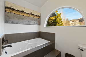 Full bath with toilet and a tub with jets