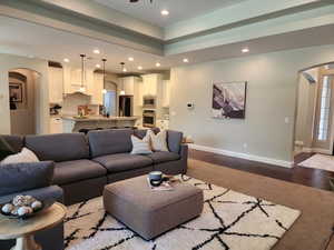 Living area featuring arched walkways, dark wood-style flooring, recessed lighting, and a ceiling fan