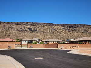 View of asphalt road with a mountain view, curbs, and a residential view