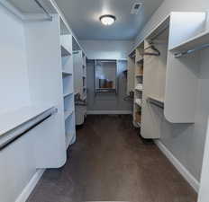Walk in closet featuring dark carpet