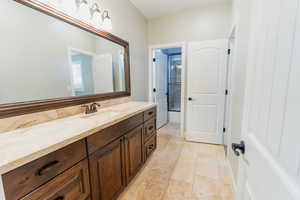 Bathroom with vanity, light tile patterned flooring, and a shower