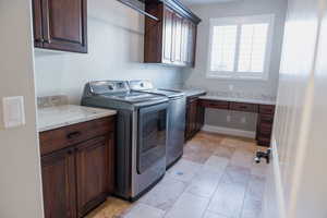 Laundry room with cabinet space, independent washer and dryer, and light tile patterned flooring