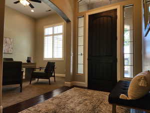 Entryway featuring dark wood-type flooring, ceiling fan, and arched walkways