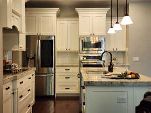 Kitchen with white cabinets, stainless steel appliances, tasteful backsplash, and pendant lighting