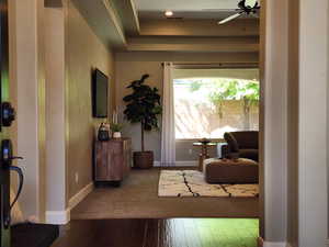 Entryway featuring hardwood / wood-style floors, a ceiling fan, and a raised ceiling