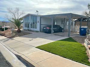 View of front of house with a carport and concrete driveway