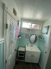 Half bath featuring a textured ceiling, vanity, and dark wood-style floors