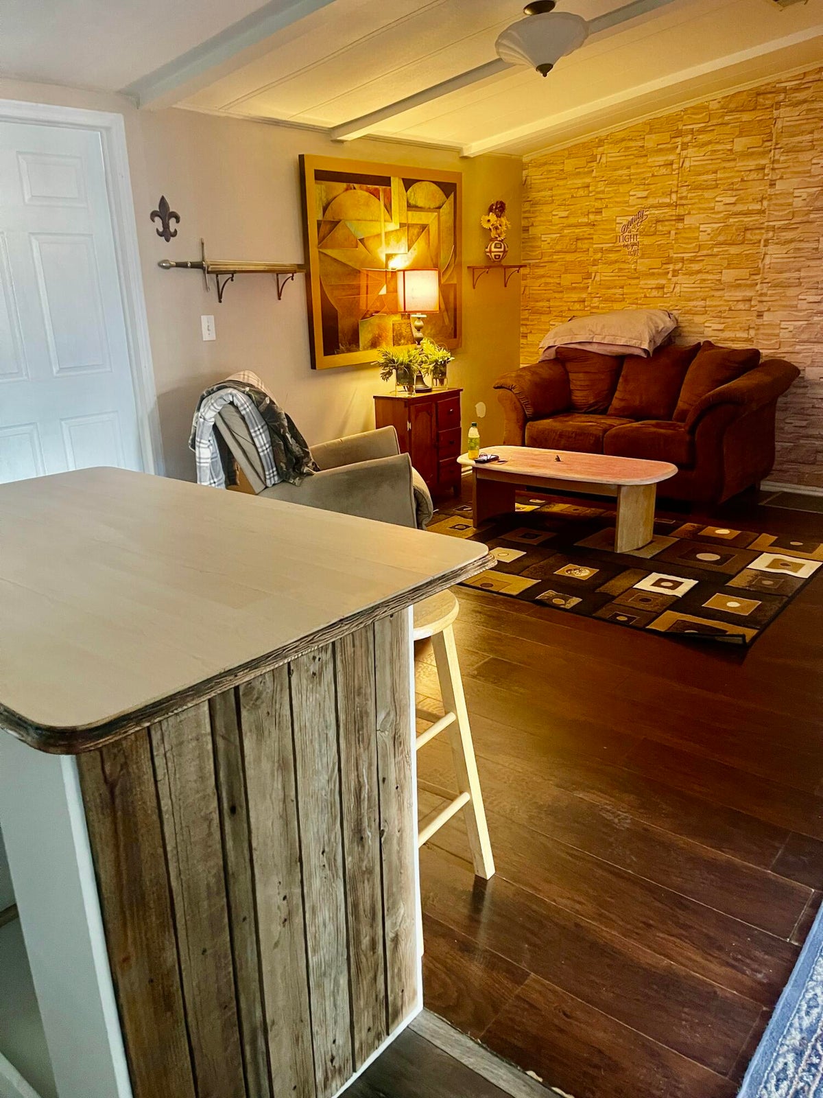 Living area featuring dark wood-type flooring and beam ceiling